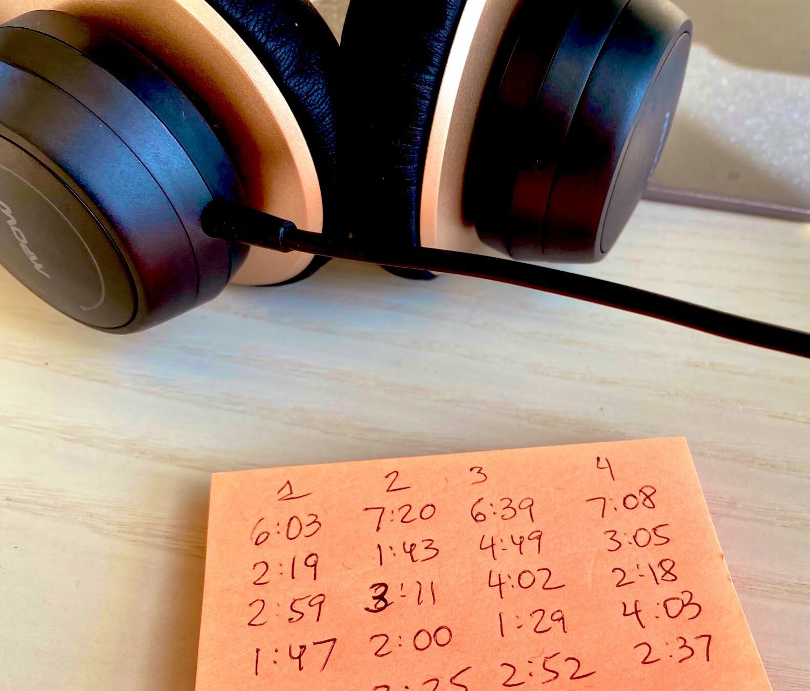 headphones above post-it note with track timings from the Bach Orchestral Suites